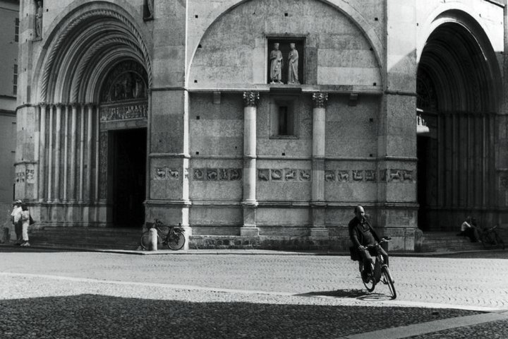 building in parma and man on bike