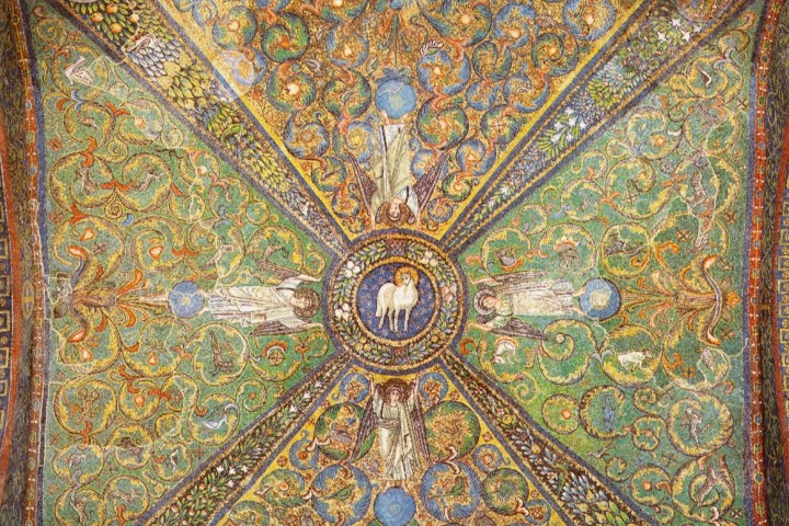 Intricate mosaic ceiling with lamb and angels surrounded by floral patterns in green and gold hues.